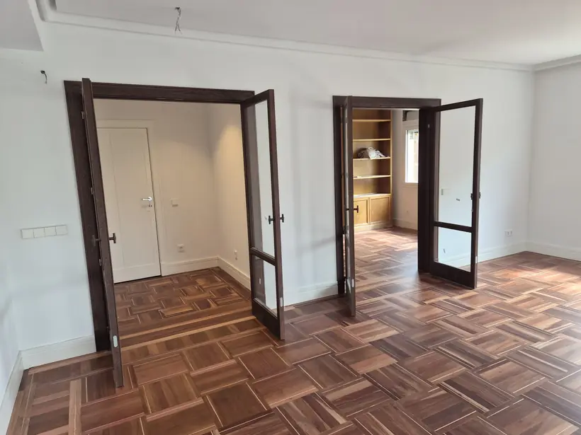 Salón reformado con parquet de nogal y carpintería de madera restaurada