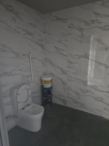 Paño de porcelánico efecto mármol con inodoro suspendido