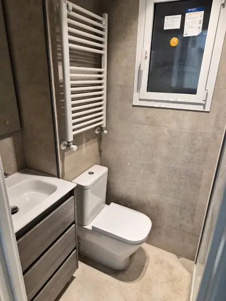 Aseo terminado con lavabo sobre mueble y ventana nueva