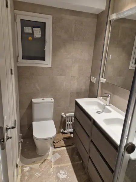 Baño con mueble de doble cajón, espejo y mampara de vidrio