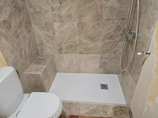 Baño con banco de obra alicatado y plato de ducha extraplano