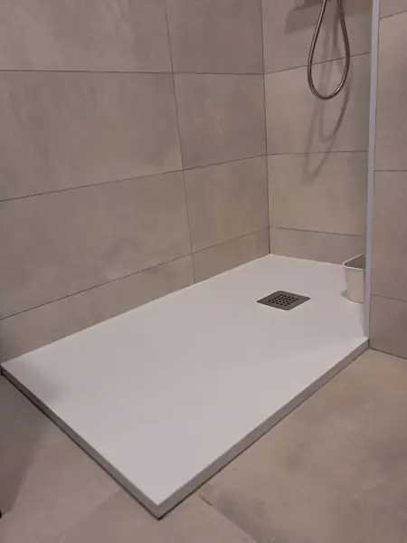 Plato de ducha extraplano blanco sobre porcelánico gris de gran formato