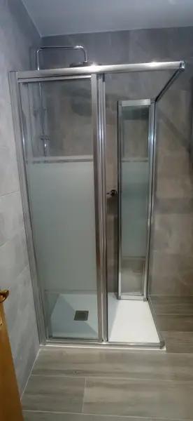 Mampara corredera de ducha instalada sobre plato extraplano blanco