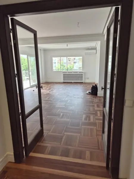 Puertas de madera con vidrio abiertas hacia el salón reformado