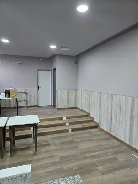 Sala con revestimiento mural de media altura y suelo imitación madera