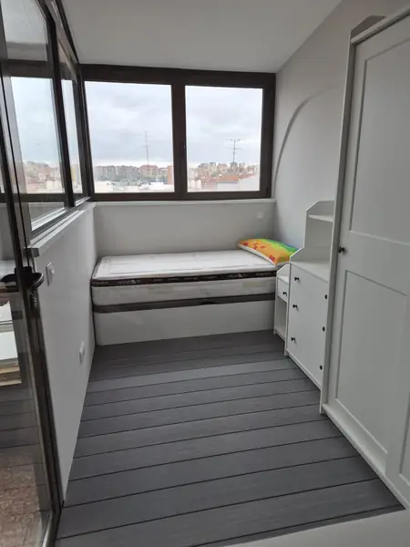 Terraza cerrada con tarima tecnológica gris y armario a medida