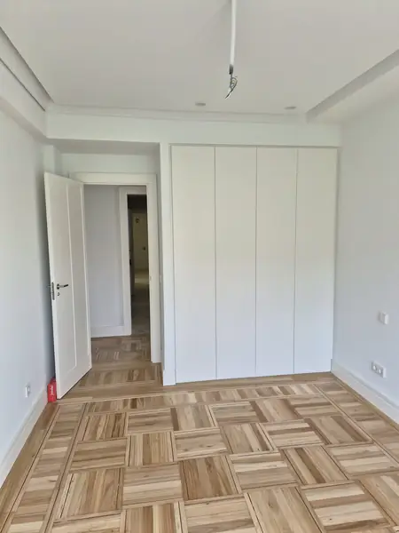 Dormitorio con tarima de roble claro y ventana nueva