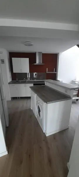 Cocina con isla, campana extractora y suelo de tarima